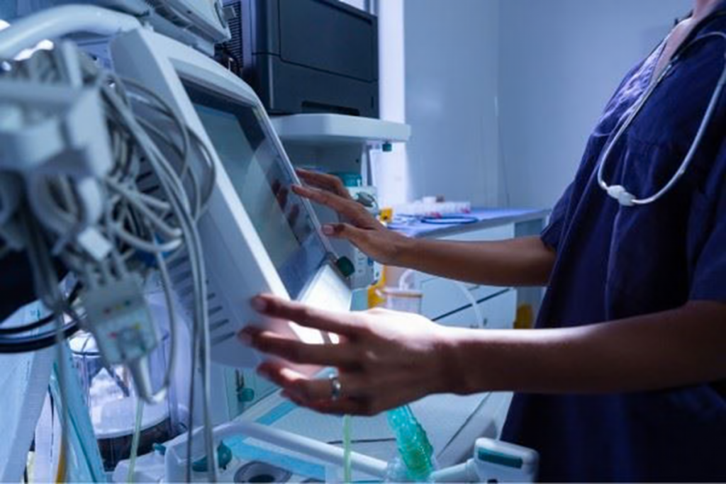 hospital worker looking at hospital equipment screen